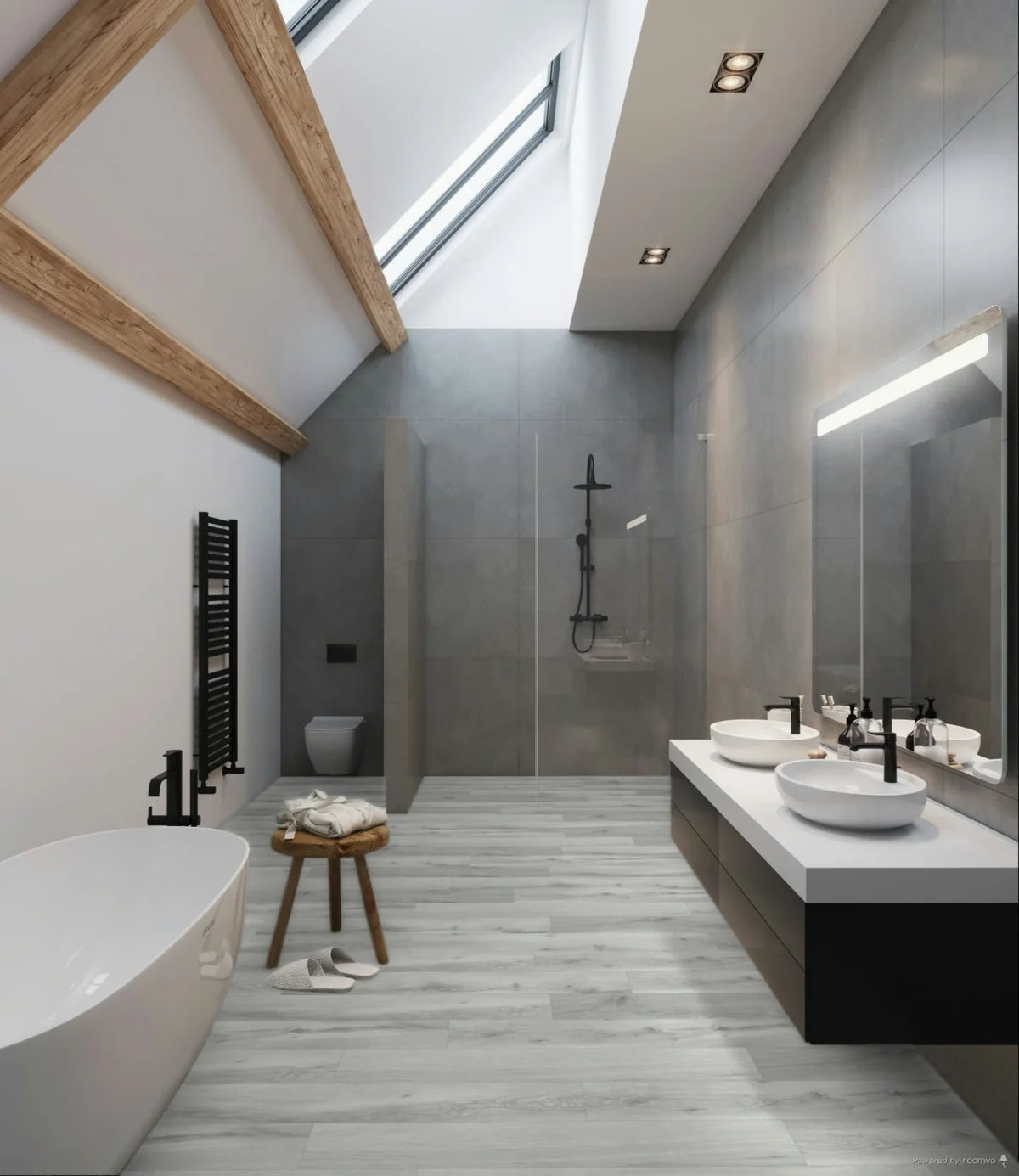 A modern bathroom interior with a freestanding white bathtub, double vessel sinks on a long white vanity, a walk-in shower, gray wall tiles, light wood flooring, and exposed wooden beams under a skylight.