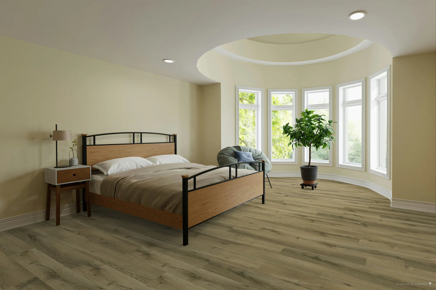 A modern bedroom featuring light gray wood-look plank flooring, beige walls, a wooden and black metal bed frame, a matching nightstand, and a large potted plant near a curved bay window.