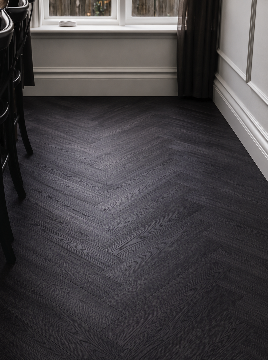 Black Ash Herringbone Luxury Click Vinyl Flooring featuring a dark wood-effect herringbone pattern, realistic oak grain texture and deep charcoal tones. Waterproof click vinyl flooring shown in a modern dining or hallway space, highlighting durable wood-look flooring, low-maintenance performance and premium herringbone design for contemporary interiors.