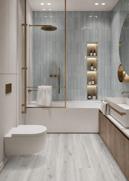 Kirkstone Grey Oak Luxury Click Vinyl Flooring 5mm in a contemporary bathroom with light blue wall tiles, brushed brass fittings, white bath and toilet, illuminated shelving and a modern wood vanity.