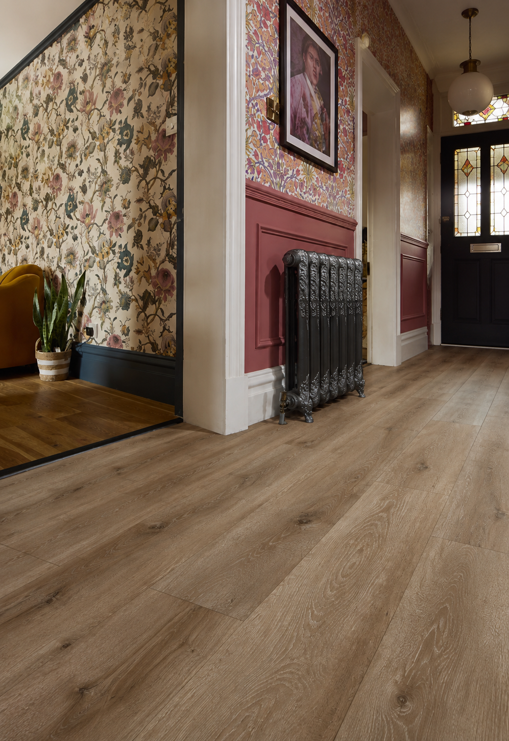 Thetford Walnut wood-effect flooring planks in a stylish hallway with floral wallpaper, period radiator and warm vintage décor.